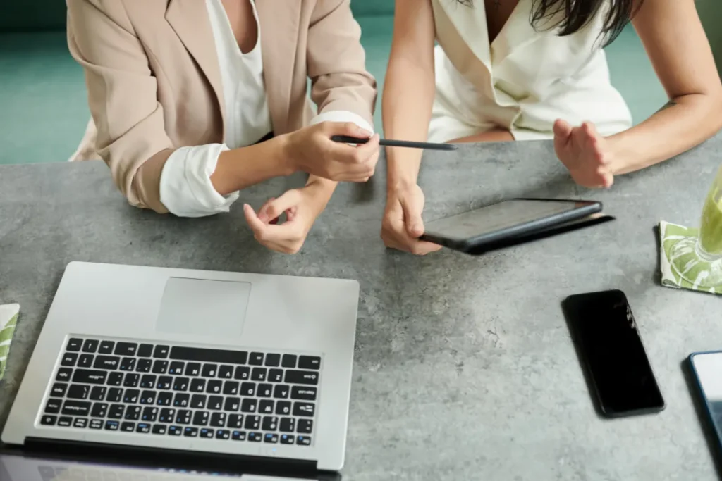 Profissionais analisando landing page em tablet e notebook durante reunião estratégica focada em otimização de conversão